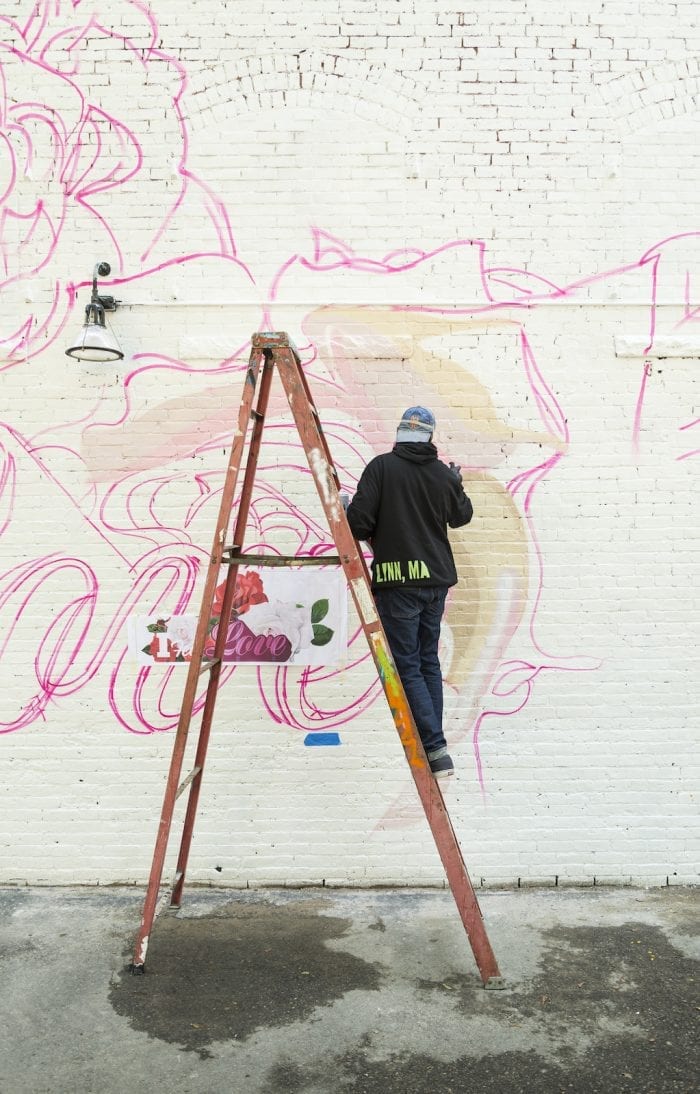 Artist Cey Adams starts adding detail to his mural on Munroe Street on Saturday.