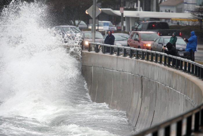 Wave watchers along Lynn Shore Drive take videos and photos as each wave rolls in at high tide.