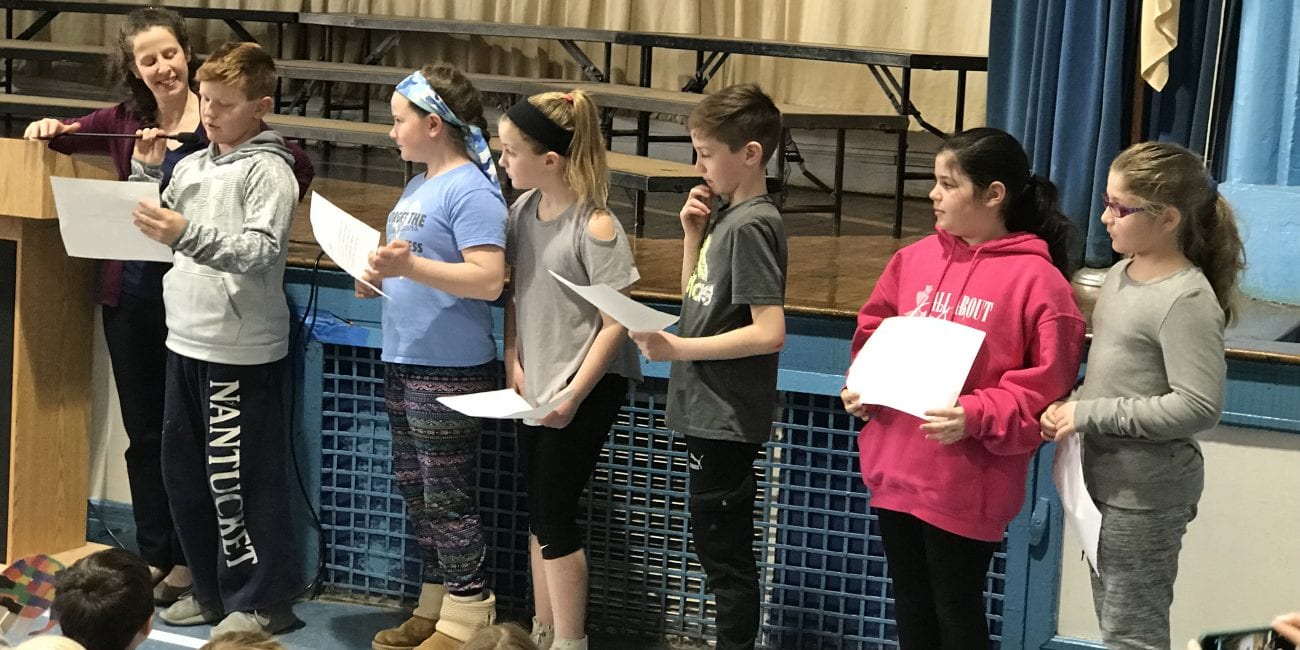 Third graders Max Battinelli (left), Victoria Pierro, Jane Raymond, Bogdan Lutic, Lila Schwartz and Sophia Zanni present their acts of kindness during a school-wide assembly to wrap up Hadley School's Great Kindness Challenge.