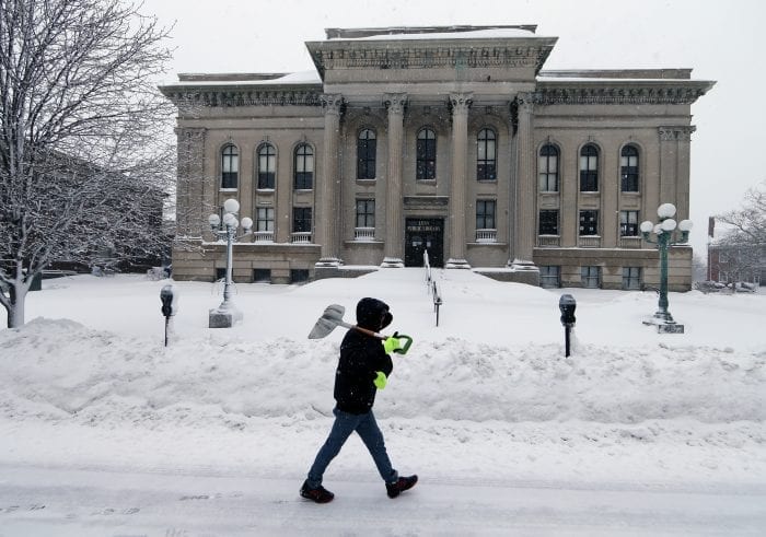 Lynn, MA—Tue March 13, 2018—Ryan Hernandez of Lynn walks past the closed Lynn Public Library to do some shoveling in downtown Lynn. The storm forced the Library to close for the day.