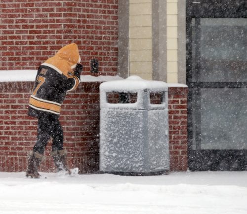 Lynn, MA—Tue March 13, 2018—Shopper at CVS on Boston Street Lynn shields face from blowing snow during the Tuesday storm.