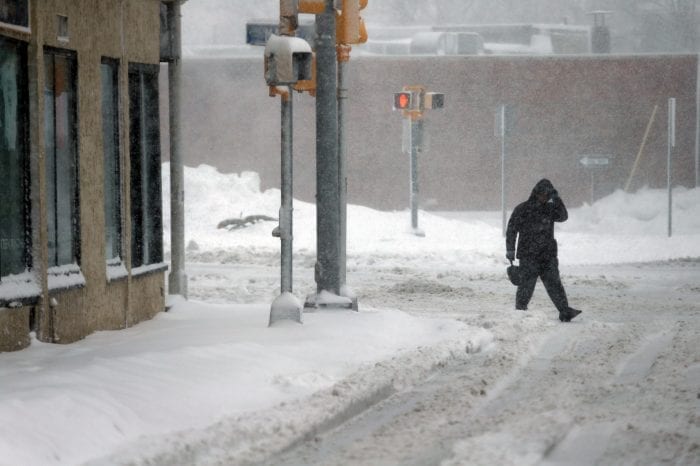 Lynn, MA—Tue March 13, 2018—Unplowed sidewalk forces this pedestrian to walk on the street at the corner of Western Ave and Chestnut Street in Lynn during the storm.