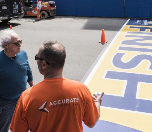 Accurate Graphic Inc. owner Peppy Bolognese, left, and employee Anthony Bisenti speak at the 122nd Boston Marathon finish line, having finished laying it out on Boylston Street in Boston on Thursday.
