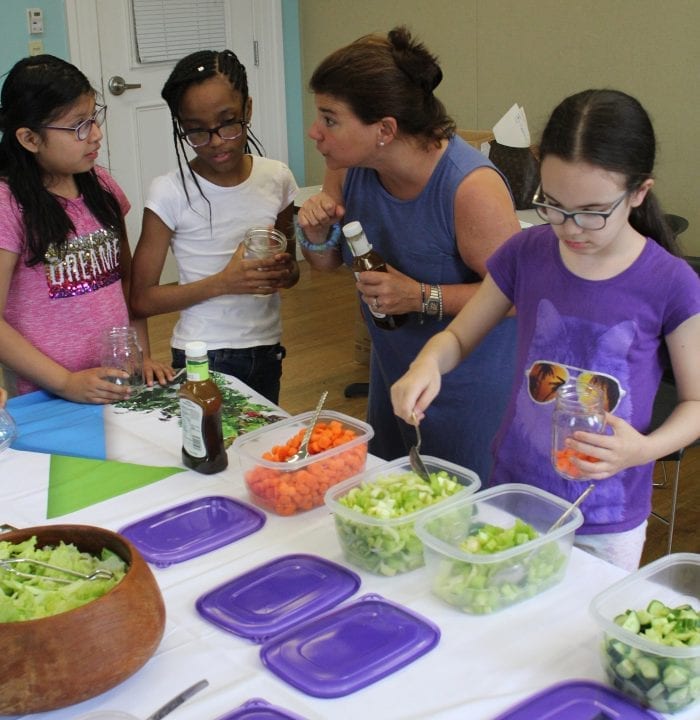 Lynn, Ma. 5-3-18. Hailley Mendez, left, Laisha Mercedes Christine Meninno and Jasmin Guzman create salads in a jar at Girl's Inc. It was to be a Mother's Day gift.