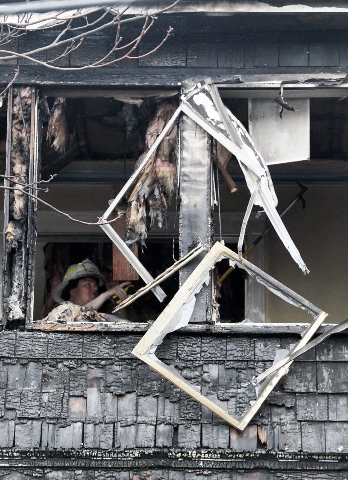 Lynn, MA--Fri May 4, 2018--Lynn firefighter checks ceiling of a two-alarm fire scene at 15 Dorinda Circle shortly before 9 a.m. Friday morning.
