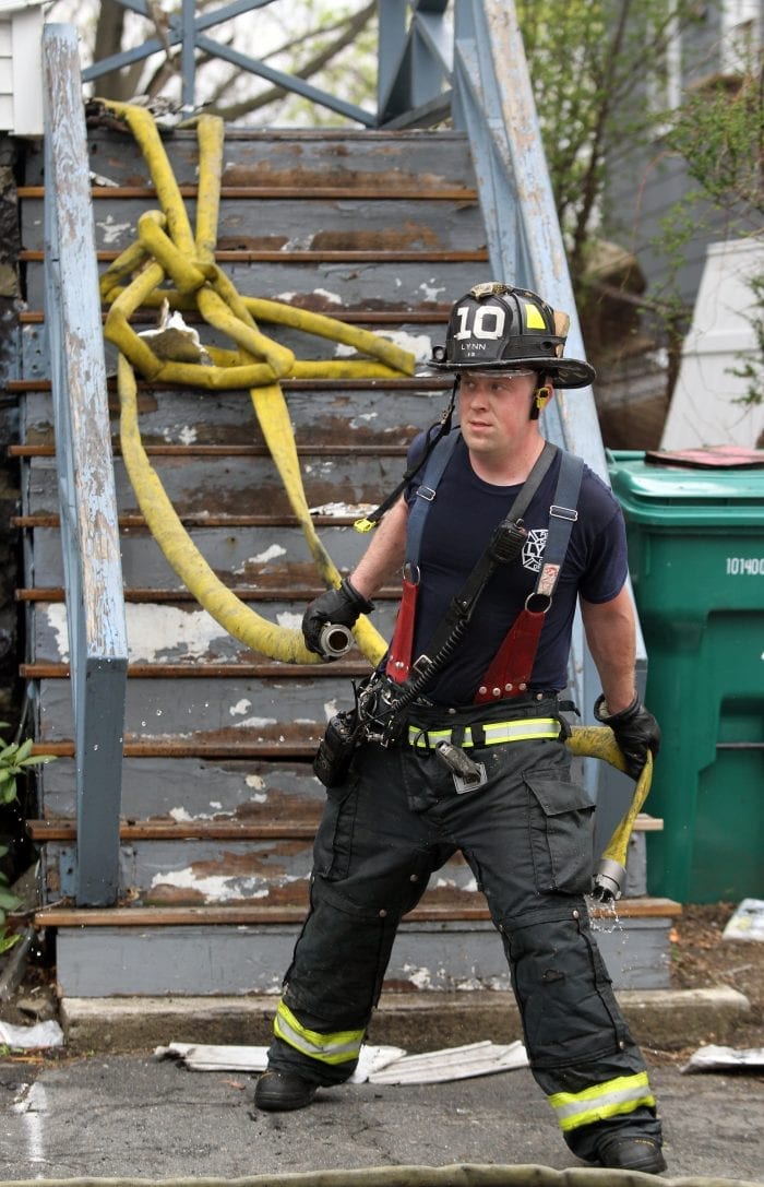 Lynn, MA--Fri May 4, 2018--Lynn firefighter Brett Johnson pulls hoses out of of a two-alarm fire scene at 15 Dorinda Circle.