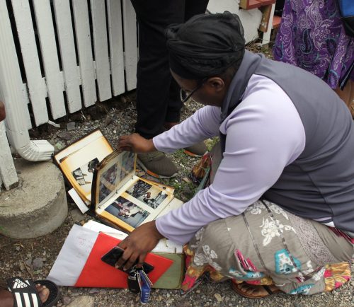 Lynn, MA--Fri May 4, 2018--Shirley Saintvil checks through a charred family photo album that was saved by firefighters at a two-alarm fire at 15 Dorinda Circle shortly before Friday morning.